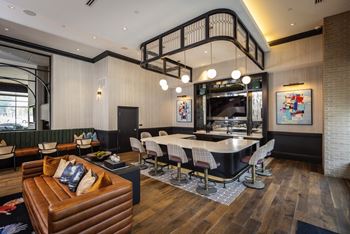 A room with a large table and chairs and a staircase in the background